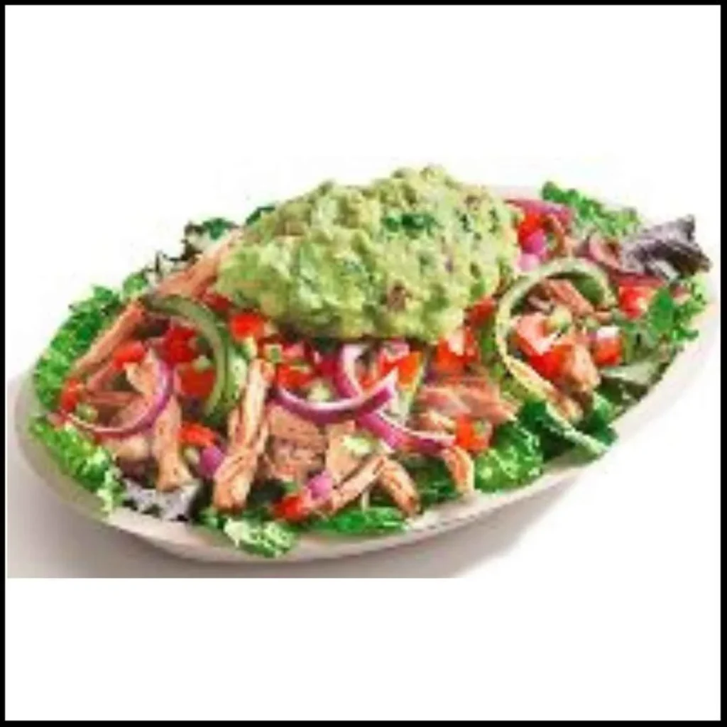 Chipotle Wholesome Bowl with Carnitas – A Flavorful and Nutritious Choice! Chipotle Wholesome Bowl with Carnitas, featuring slow-cooked pork, fresh greens, bell peppers, onions, tomatoes, and a generous scoop of guacamole.