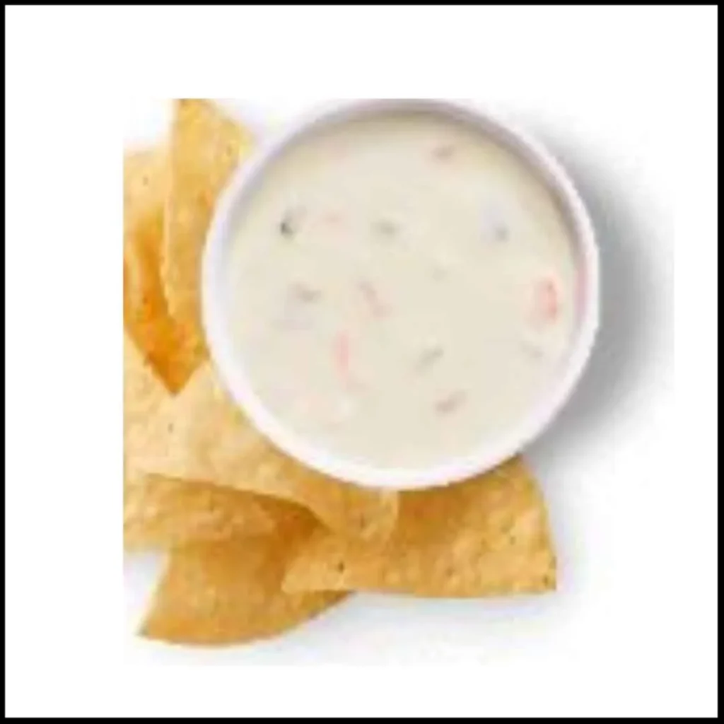 Queso Blanco Dip with Tortilla Chips – A Creamy and Delicious Snack A bowl of creamy white queso blanco dip with visible bits of peppers, served with crispy tortilla chips.